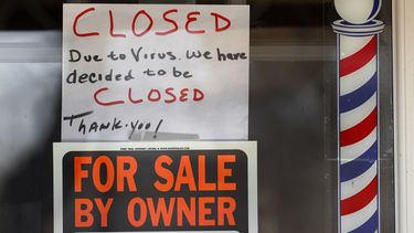 Un letrero anuncia el cierre de una barber&iacute;a&nbsp;en tiempos de coronavirus, junto a otro que informa que el negocio est&aacute; en venta.&nbsp; 