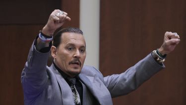 El actor Johnny Depp demuestra cómo afirma que se protegió de un presunto ataque de su ex esposa Amber Heard mientras testifica durante su juicio por difamación contra Heard, en el juzgado de circuito del condado de Fairfax en Fairfax, Virginia, el 20 de abril de 2022.&nbsp;