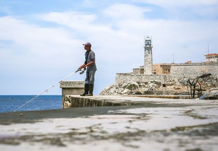 Un hombre pesca desde el muro del Malecón, en La Habana.