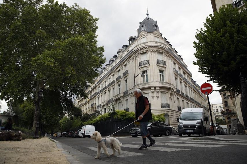 En esta foto del 13 de agosto de 2020, un hombre pasea a su perro frente a un edificio de apartamentos propiedad de Jeffrey Epstein en París. El agente de modelos Jean-Luc Brunel, quien tenía una relación estrecha con Epstein, fue arrestado el 16 de diciembre bajo sospecha de violación de menores y otros crímenes.&nbsp;