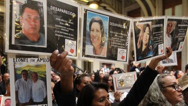 Familiares de personas desaparecidas muestran las fotografías de sus seres queridos durante un acto con el presidente de&nbsp;México, Andrés, Manuel López Obrador, este domingo, en Ciudad de&nbsp;México.