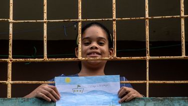 &nbsp; En esta imagen, tomada el 8 de mayo de 2020, Ana Laura Ram&iacute;rez Lavandero, de 10 a&ntilde;os, sostiene un dibujo en el que expresa su deseo de viajar a la playa, desde el balc&oacute;n de su casa en La Habana, Cuba. El &uacute;nico momento en que ha podido salir de su casa en casi dos meses fue para ir de emergencia al dentista. Las escuelas est&aacute;n cerradas, y como muchas personas en Cuba no tienen internet, el Ministerio de Educaci&oacute;n transmite las lecciones por la televisi&oacute;n estatal.