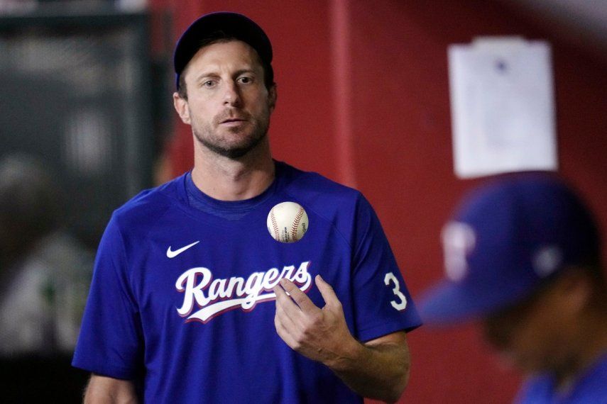 En foto del 22 de agosto del 2023, el pitcher de los Rangers de Texas, Max Scherzer, juega con una pelota en el dugout en la séptima entrada del choque ante los Diamondbacks de Arizona. En foto del 22 de agosto del 2023, el pitcher de los Rangers de Texas, Max Scherzer, juega con una pelota en el dugout en la séptima entrada del choque ante los Diamondbacks de Arizona.