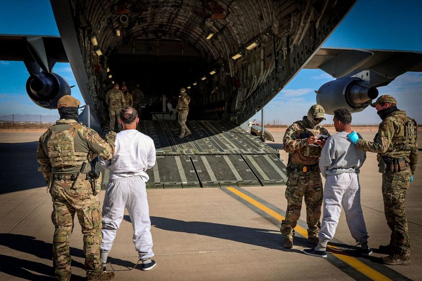 Miembros del Ejército montan en un avión militar a inmigrantes convictos.