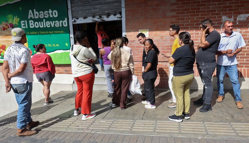 La gente hace fila frente a un supermercado en Caracas el 3 de enero de 2026, después de que las fuerzas estadounidenses capturaran al dictador venezolano Nicolás Maduro.