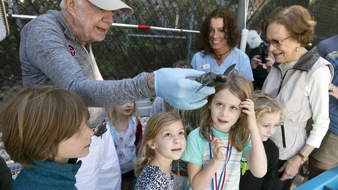 El expresidente Jimmy Carter sostiene en su mano una tortuga.&nbsp;