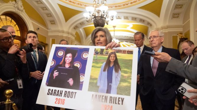 La senadora Joni Ernst, republicana por Iowa, sostiene un cartel con fotografías de dos víctimas de asesinato Sarah Root y Laken Riley en el Capitolio, en Washington, el martes 27 de febrero de 2024.   