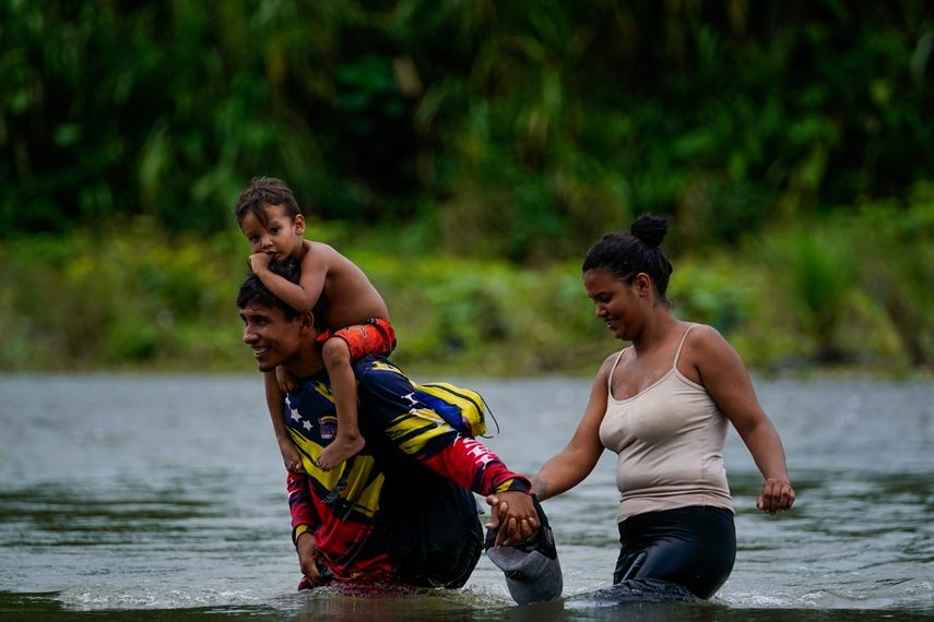 Migrantes venezolanos vadean el río Tuquesa tras cruzar a pie el Tapón del Darién, en Bajo Chiquito, Panamá, el 4 de octubre de 2023.