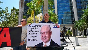 Personas protestan para exigir la sentencia máxima para el exembajador de Estados Unidos en Bolivia, Víctor Manuel Rocha, acusado de espiar para Cuba, frente a la Corte Wilkie D. Ferguson Jr. en Miami, Florida, el 12 de abril de 2024, mientras se llevaba a cabo el juicio contra el espía.