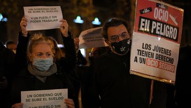 Manifestantes en Barcelona, España, sostienen carteles durante una manifestación contra las nuevas restricciones del coronavirus.