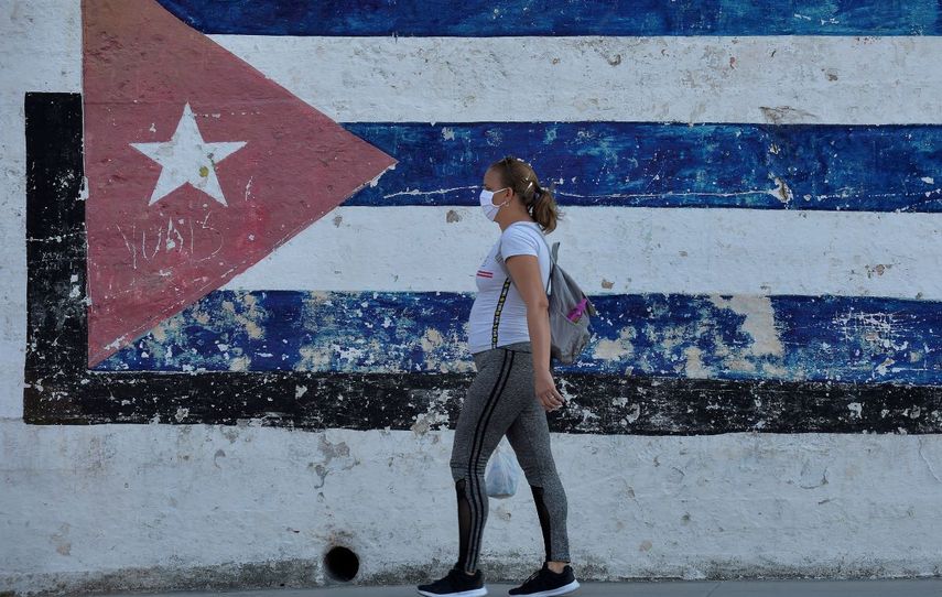 Una mujer camina por las calles de La Habana, Cuba, con una mascarilla de protección contra el coronavirus, el 28 de marzo de 2020.