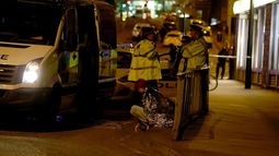 Una mujer es vista sentada en una calle cercana al&nbsp;Manchester&nbsp;Arena, junto a un grupo de policías, luego de las dos explosiones registradas cerca al lugar donde se celebraba un concierto de la cantante Ariana Grande en&nbsp;Manchester, al norte de Inglaterra, este lunes 22 de mayo de 2017.&nbsp;