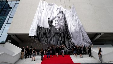 Trabajadores instalan el cartel oficial del 76º Festival de Cine de Cannes en la fachada del Palais des Festivals, en Cannes, sureste de Francia, el 14 de mayo de 2023.