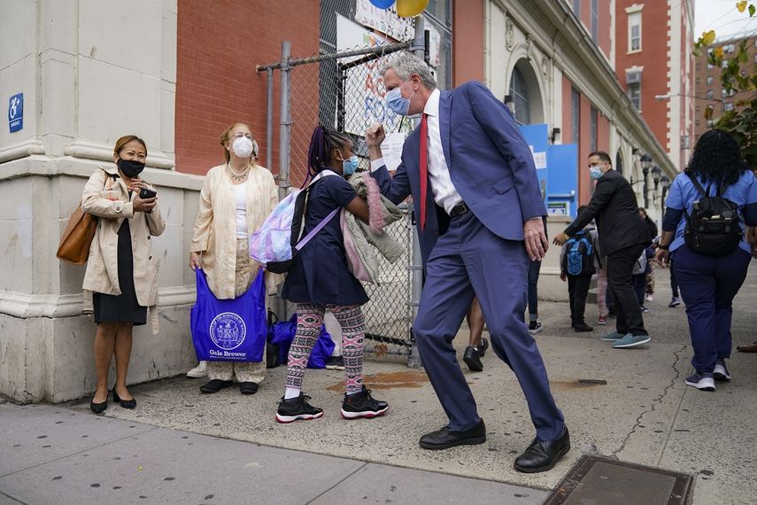 El alcalde de la ciudad de Nueva York Bill de Blasio saluda a estudiantes en una escuela de la ciudad el 29 de septiembre del 2020.&nbsp;