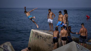 Un hombre salta al mar en un rompeolas en Barcelona, España, el miércoles 12 de julio de 2023. Más de 10 regiones de España están en alerta roja por el segundo día de la última ola de calor, con temperaturas que superan los 40 grados centígrados.&nbsp;