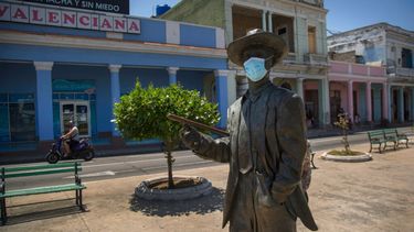La estatua del legendario cantante cubano Benny More, con una máscara contra la propagación del nuevo coronavirus, se encuentra en Cienfuegos, Cuba, el domingo 30 de mayo de 2021.