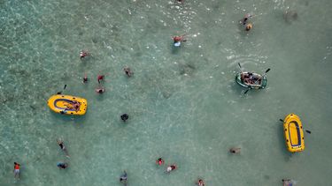 La gente nada y juega con botes en el Cayo Playuela del Parque Nacional Morrocoy, estado Falcón, Venezuela, el domingo 13 de junio de 2021. En medio de la pandemia, muchos de los sitios de turismo apenas logran sobrevivir.