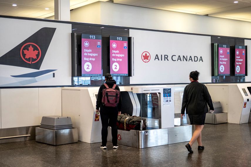 Un pasajero coloca su equipaje en un mostrador de auto check-in de Air Canada en Montreal, Quebec, el 19 de agosto de 2025.