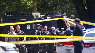 Agentes de la policía se reúnen en el sitio donde ocurrió un tiroteo.