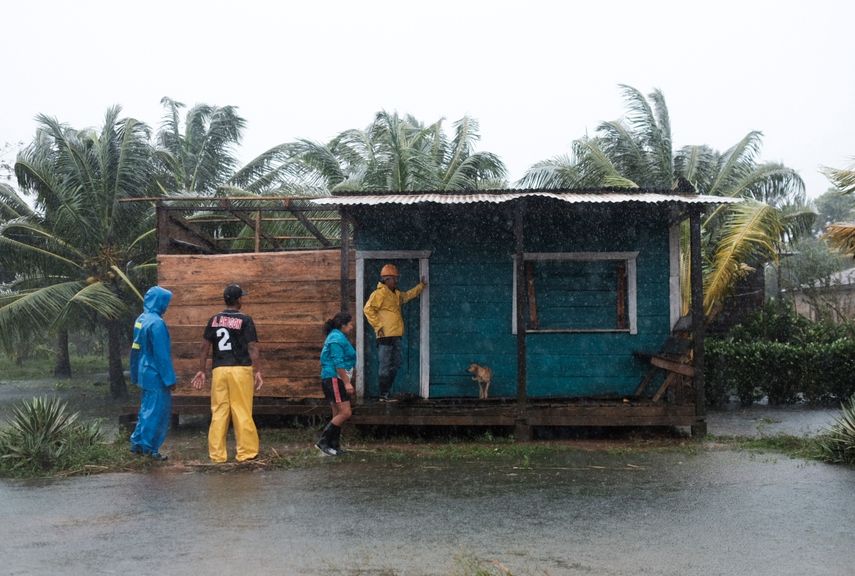 Residentes se paran afuera de una casa rodeada por las inundaciones provocadas por el huracán Eta en Wawa, Nicaragua, el martes 3 de noviembre de 2020.