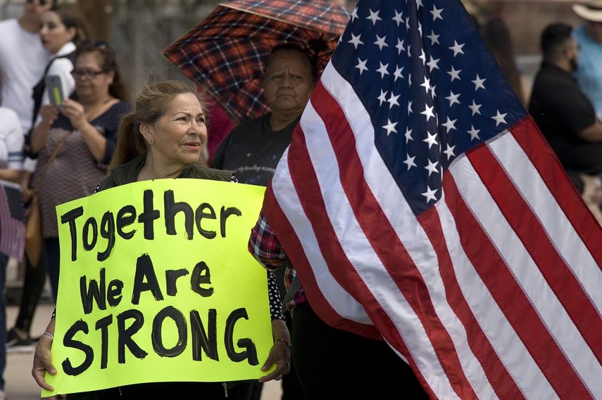Una mujer sostiene un cartel en apoyo a los inmigrantes indocumentados en California.