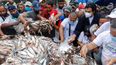 Residentes de un barrio popular de Caracas toman pescado durante un mitin de campaña organizado por Javier Bertucci y Juan Eleazar, ambos candidatos a las elecciones parlamentarias, convocadas por el régimen.
