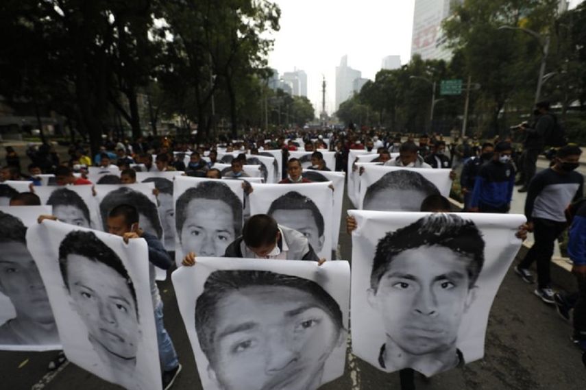Estudiantes normalistas muestran las fotografías de los 43 estudiantes desaparecidos de la Escuela Normal Rural de Ayotzinapa al acompañar a los familiares en una marcha en el sexto aniversario de la desaparición de los 43 estudiantes, en Ciudad de México, el sábado 26 de septiembre de 2020. ()