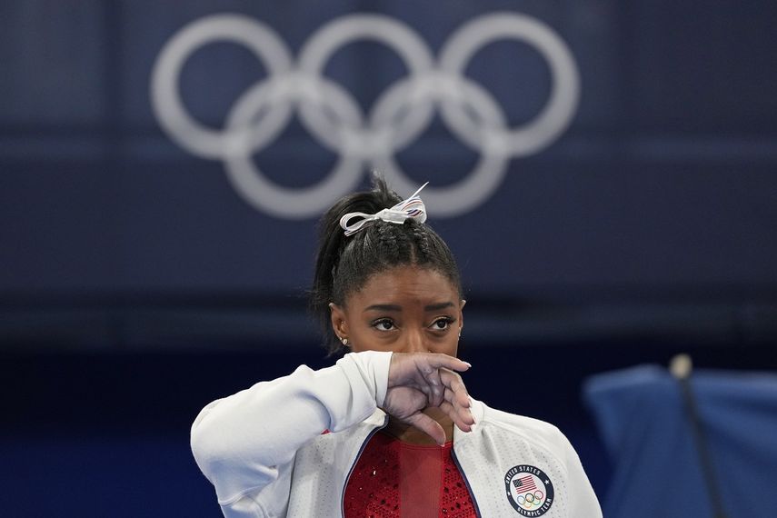 La estadounidense Simone Biles observa la actuación de otras gimnastas tras retirarse de la final por equipos de los Juegos de Tokio 2020 por una aparente lesión, el 27 de julio de 2021, en Tokio. 