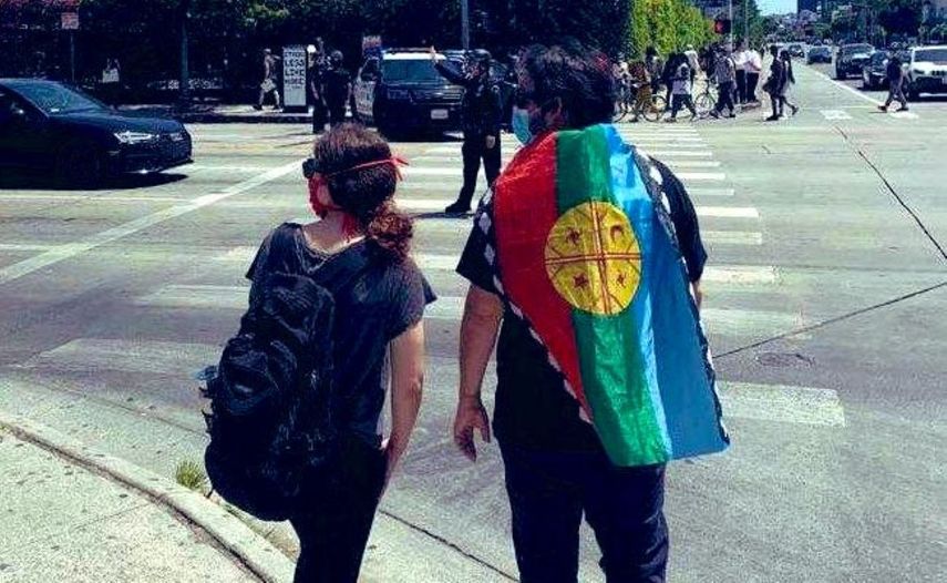 Manifestantes de origen hispano participando en las protestas en Miami con la bandera Wenufoye o Mapuche, un movimiento chileno al que se le vincula con la izquierda radical.