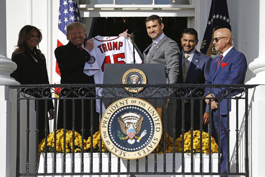 El primera base de los Nacionales de Washington, Ryan Zimmerman (centro), entrega una camiseta al presidente Donald Trump durante un evento para celebrar la victoria del equipo en la Serie Mundial, el lunes 4 de noviembre de 2019, en la Casa Blanca.&nbsp;