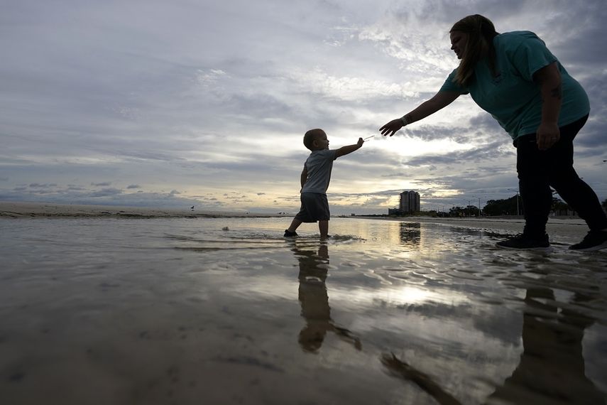 Nikita Pero de Gulfport, Mississippi, camina con su hijo Vinny Pero, de 2 a&ntilde;os, por la playa en el Golfo de M&eacute;xico, en Biloxi, Mississippi, el lunes 14 de septiembre de 2020.&nbsp;