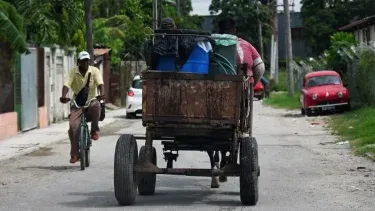 Un cubano transporta contenedores de agua en un carro tirado por caballos en La Habana, Cuba.