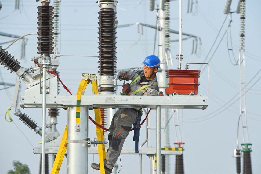 Un empleado trabaja en una línea del alta tensión.