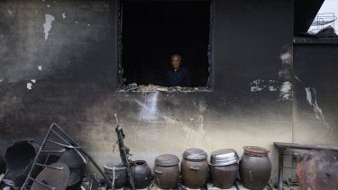 Kim Seung-weon permanece entre los restos quemados de su casa, dos días después de que un incendio forestal arrasara su aldea, en Andong, el 27 de marzo de 2025. La lluvia caída durante la noche ayudó a sofocar algunos de los peores incendios forestales de la historia de Corea del Sur, informaron las autoridades el 28 de marzo, mientras que la cifra de muertos por los incendios sin precedentes, que duraron casi una semana, ascendió a 28.&nbsp; 