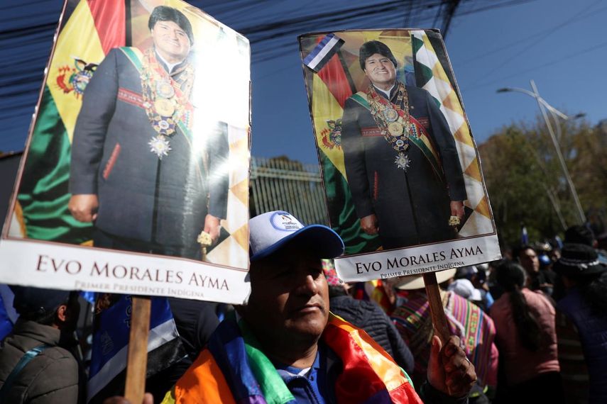 Un seguidor del expresidente de Bolivia Evo Morales, al sostener carteles con imágenes del exmandatario, a las afueras de la sede del Tribunal Supremo Electoral (TSE) de Bolivia, en La Paz.