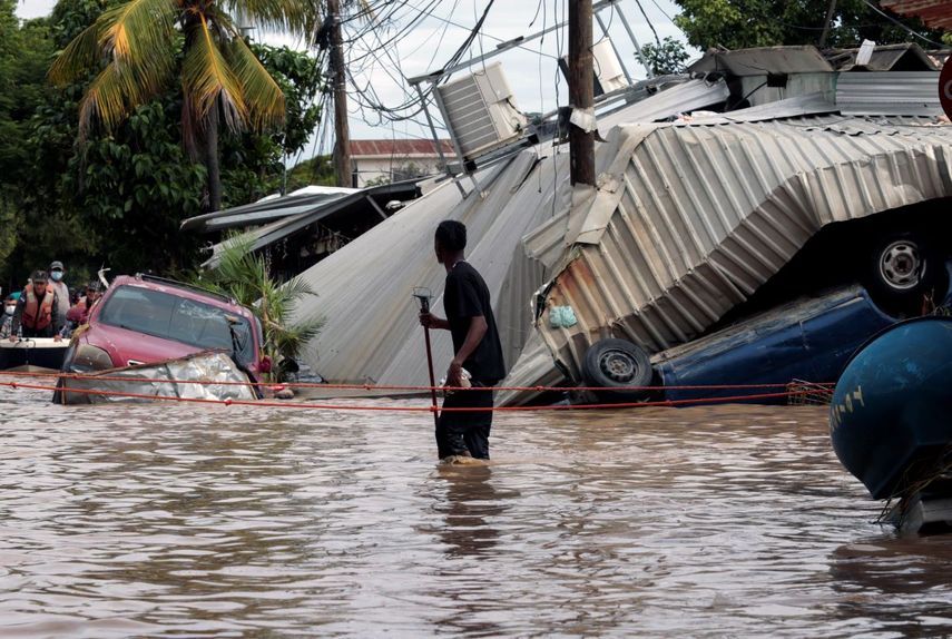 En esta foto de archivo del 6 de noviembre de 2020, un residente que camina por una calle inundada observa los daños causados ​​por el huracán Eta en Planeta, Honduras. Las familias hondureñas y guatemaltecas inundadas que quedaron varadas en los tejados de los barrios más marginados tras el paso de los huracanes Eta e Iota presagian una nueva ola de migración, según observadores de la región.