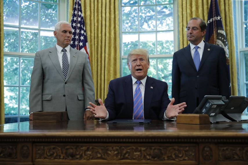 El presidente Donald Trump durante una ceremonia en la Oficina Oval, acompañado del vicepresidente Mike Pence, a la izquierda, y el secretario de Salud y Servicios Humanos, Alex Azar, el lunes 1 de julio de 2019, en Washington.