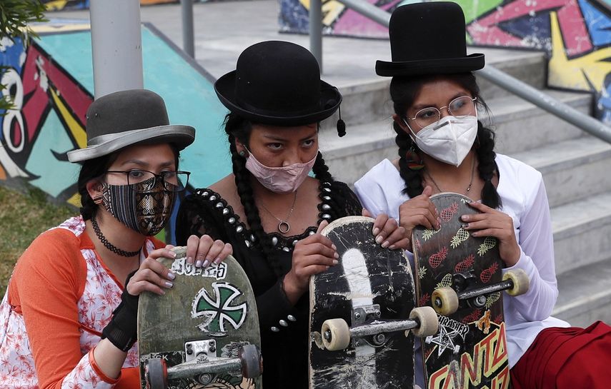 Yanira Villarreal, izquierda, Ayde Choque, centro, y Milenda Limachi son parte del grupo de mujeres jóvenes llamado ImillaSkate que usan la ropa tradicional indígena como una declaración de orgullo de su cultura indígena al andar en skate. 
