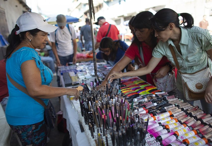 La maestra Daixy Ag&uuml;ero, a la izquierda, vende productos de maquillaje en un mercado callejero en Caracas, Venezuela.&nbsp;
