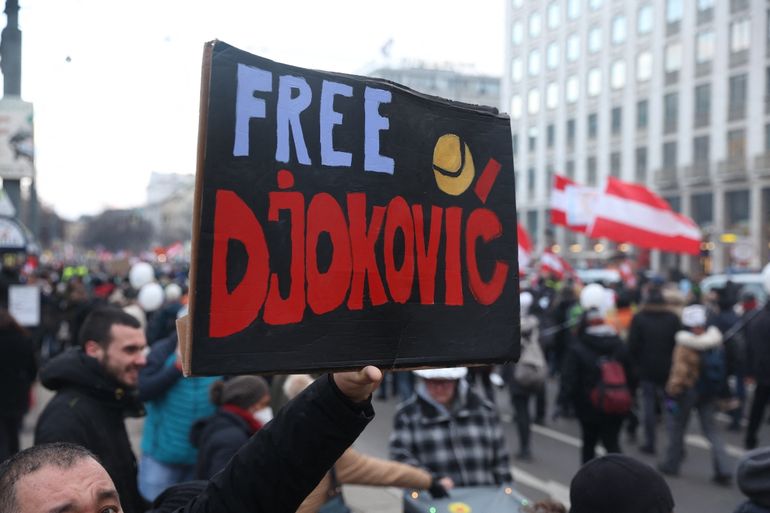 Un hombre sostiene un cartel que dice "Liberen a Djokovic" mientras la gente se manifiesta en contra de las medidas del gobierno austriaco tomadas para limitar la propagación del coronavirus durante una protesta el 8 de enero de 2022 en Viena, en medio de la pandemia del nuevo coronavirus / COVID-19.