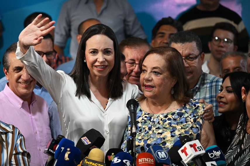 La líder opositora venezolana María Corina Machado (i) hace gestos junto a su reemplazante para las próximas elecciones nacionales, Corina Yoris (d), durante una conferencia de prensa en Caracas, el 22 de marzo de 2024.