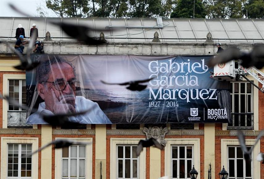 Un grupo de personas cuelga una valla con la fotografía del escritor colombiano Gabriel García Márquez en la Alcaldía de Bogotá (Colombia). Foto: EFE