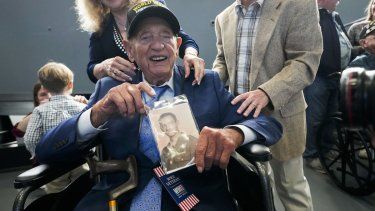 El veterano de la Segunda Guerra Mundial Joseph Eskenazi, el veterano vivo de mayor edad que sobrevivió al ataque a Pearl Harbor, sostiene una foto de sí mismo de su juventud, durante un evento el miércoles 11 de enero de 2023 que celebra su próximo 105 cumpleaños, en el Museo Nacional a la Segunda Guerra Mundial en Nueva Orleans.&nbsp;