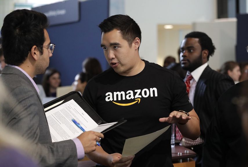 En esta fotograf&iacute;a del 17 de septiembre de 2019, el reclutador de Amazon Perry Chang habla con un prospecto durante una feria de trabajo realizada por la compa&ntilde;&iacute;a.&nbsp;
