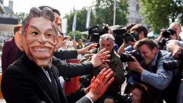 Un manifestante caracterizado como el ex primer ministro británico Tony Blair (i), participa en una protesta en el centro de conferencia Queen Elizabeth II, en el barrio de Westminster, en Londres (EFE)