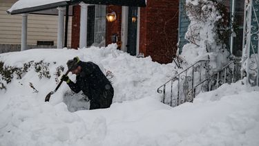 Un hombre limpia la nieve que casi ha sepultado su residencia en Nueva York.