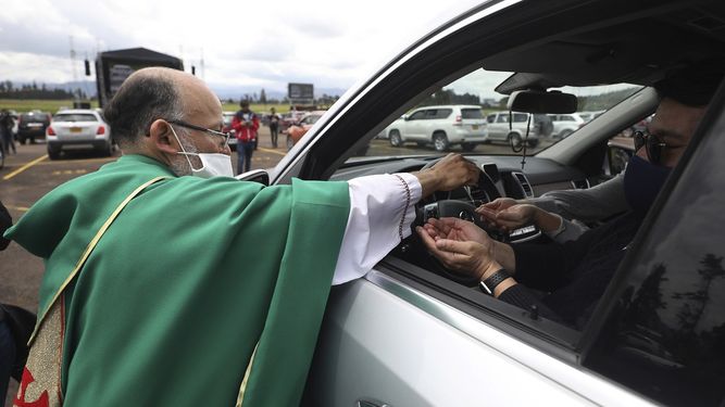 El sacerdote cat&oacute;lico Luis Carlos Ayala, con una mascarilla para protegerse del coronavirus, entrega la comuni&oacute;n a los fieles el domingo 30 de agosto de 2020 durante una misa, en Chia, Colombia.&nbsp;