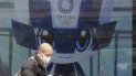 Un hombre camina frente a una pantalla donde se publicitan los Juegos Olímpicos en Tokio, el miércoles 27 de enero de 2021 Un hombre camina frente a una pantalla donde se publicitan los Juegos Olímpicos en Tokio, el miércoles 27 de enero de 2021
