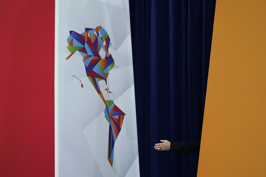 Una asistente muestra a los mandatarios del Caribe el lugar que deben ocupar para una foto de familia tras una reunión con la vicepresidenta de Estados Unidos, Kamala Harris, durante la Cumbre de las Américas, en Los Ángeles, el 9 de junio de 2022.