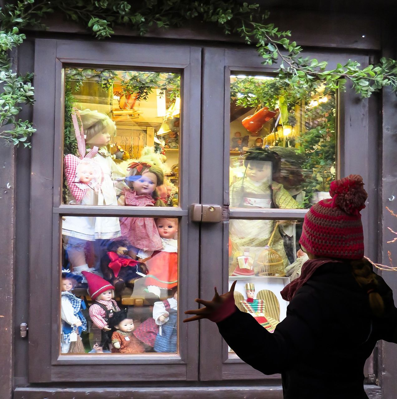 Niña observa juguetes en una tienda a través de una ventana. Niña observa juguetes en una tienda a través de una ventana.